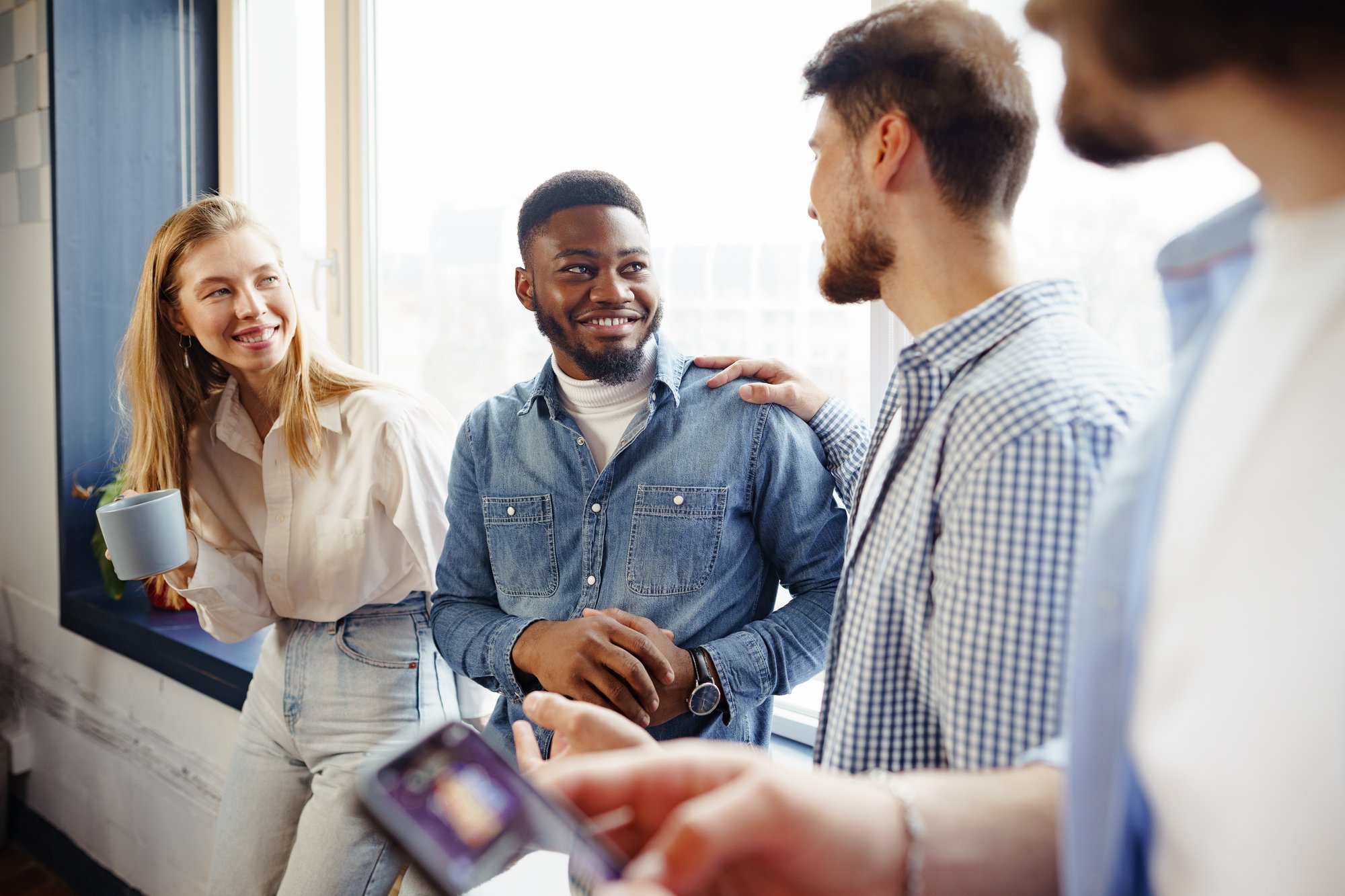 cheerful-young-business-people-have-talk-during-coffee-break-office