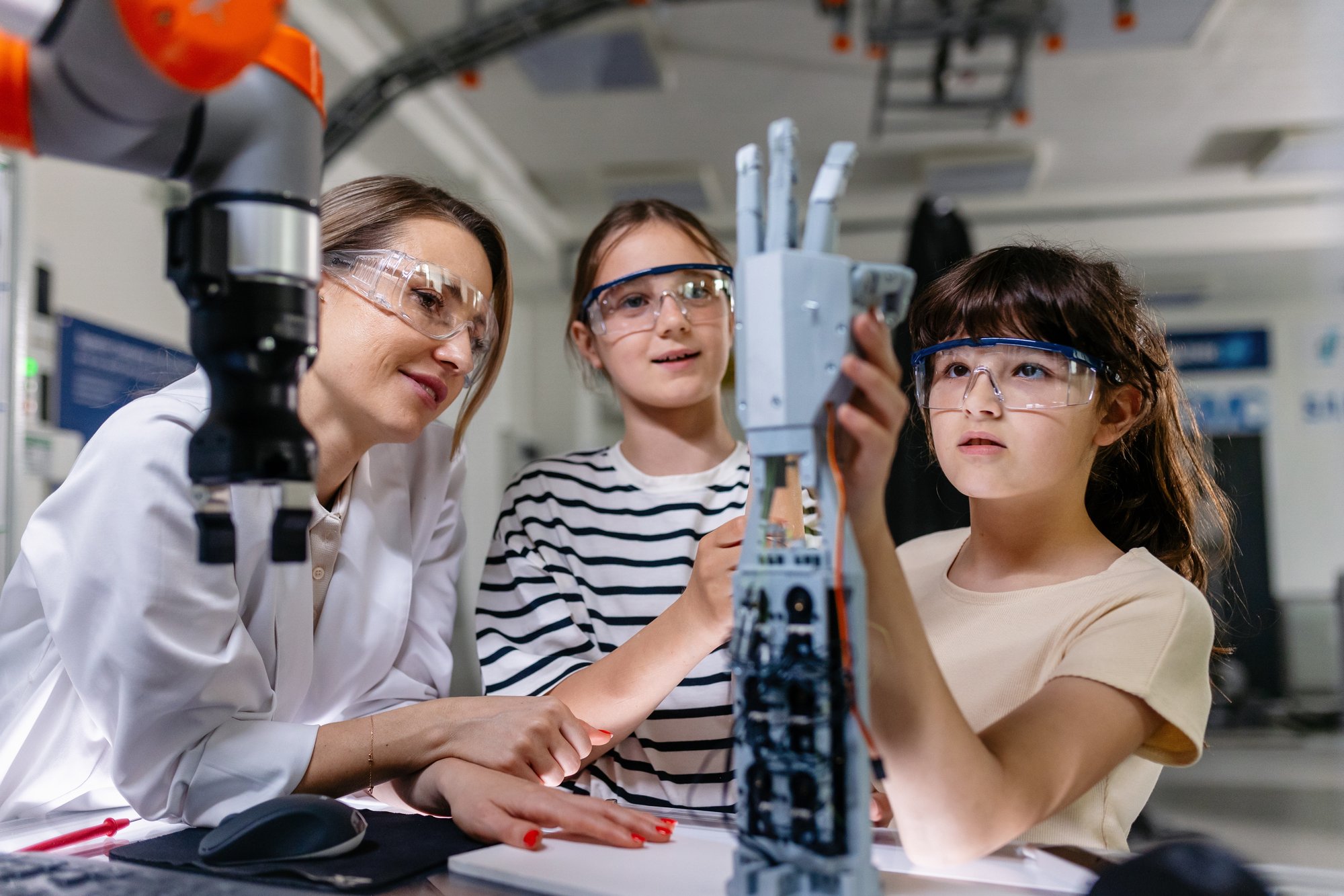 Students in a robotics classroom learning with a teacher